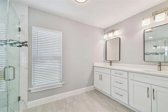 a bathroom with double sink and a mirror