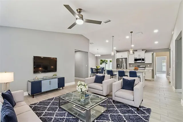 a dining room with furniture a chandelier and wooden floor