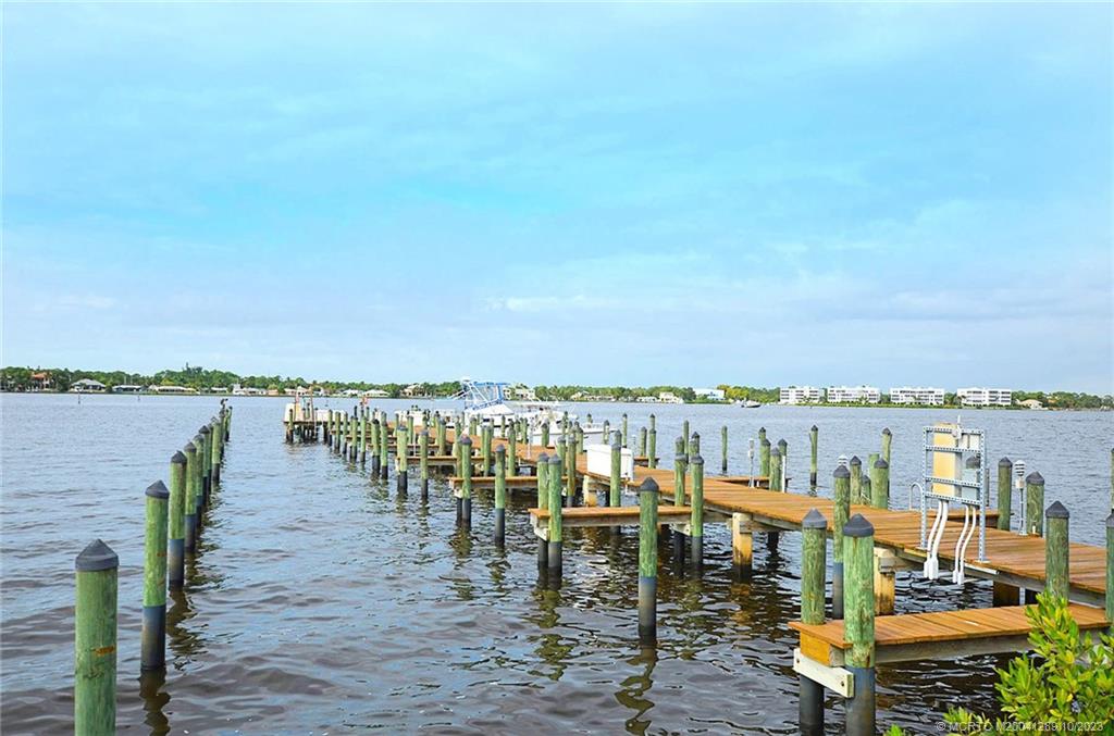 1856 Southwest Palm City Road, Unit 202 Stuart, FL 34994 - Photo 38 of 50 a view of a chairs and table on wooden floor with a lake view