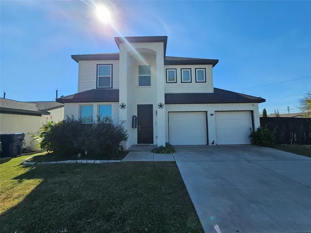 a front view of a house with a garden and yard