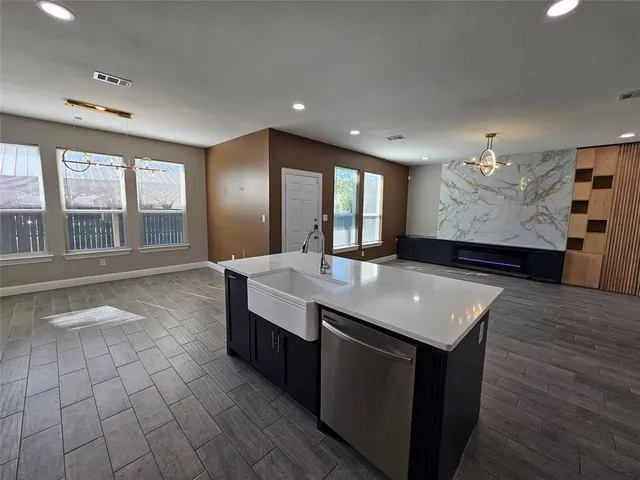 a open kitchen with stainless steel appliances granite countertop a sink a stove and a wooden floors