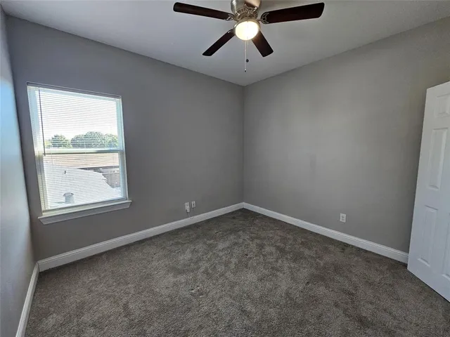 an empty room with closet and fan
