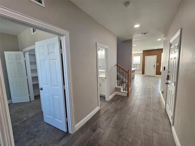 a view of a hallway with wooden floor and a living room