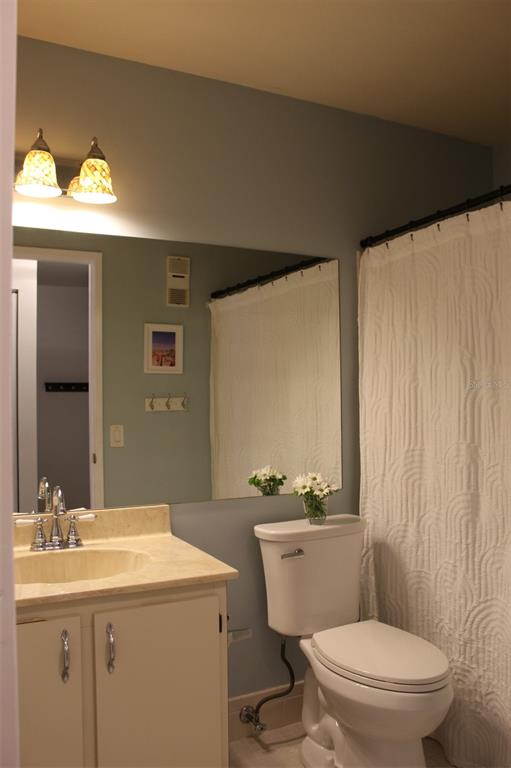 22383 Thousand Pines Lane Boca Raton, FL 33428 - Photo 17 of 28 a bathroom with a granite countertop sink toilet a mirror and a shower