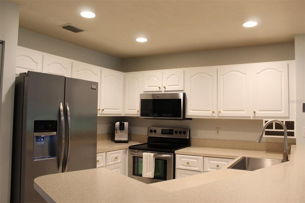 22383 Thousand Pines Lane Boca Raton, FL 33428 - Photo 3 of 28 a kitchen with stainless steel appliances a refrigerator a stove a sink a microwave and cabinets