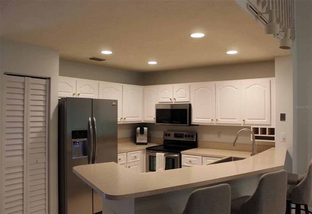 22383 Thousand Pines Lane Boca Raton, FL 33428 - Photo 5 of 29 a kitchen with stainless steel appliances a refrigerator a sink a stove a table and chairs