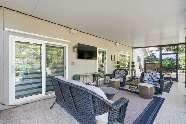 a living room with stainless steel appliances kitchen island granite countertop furniture and a window