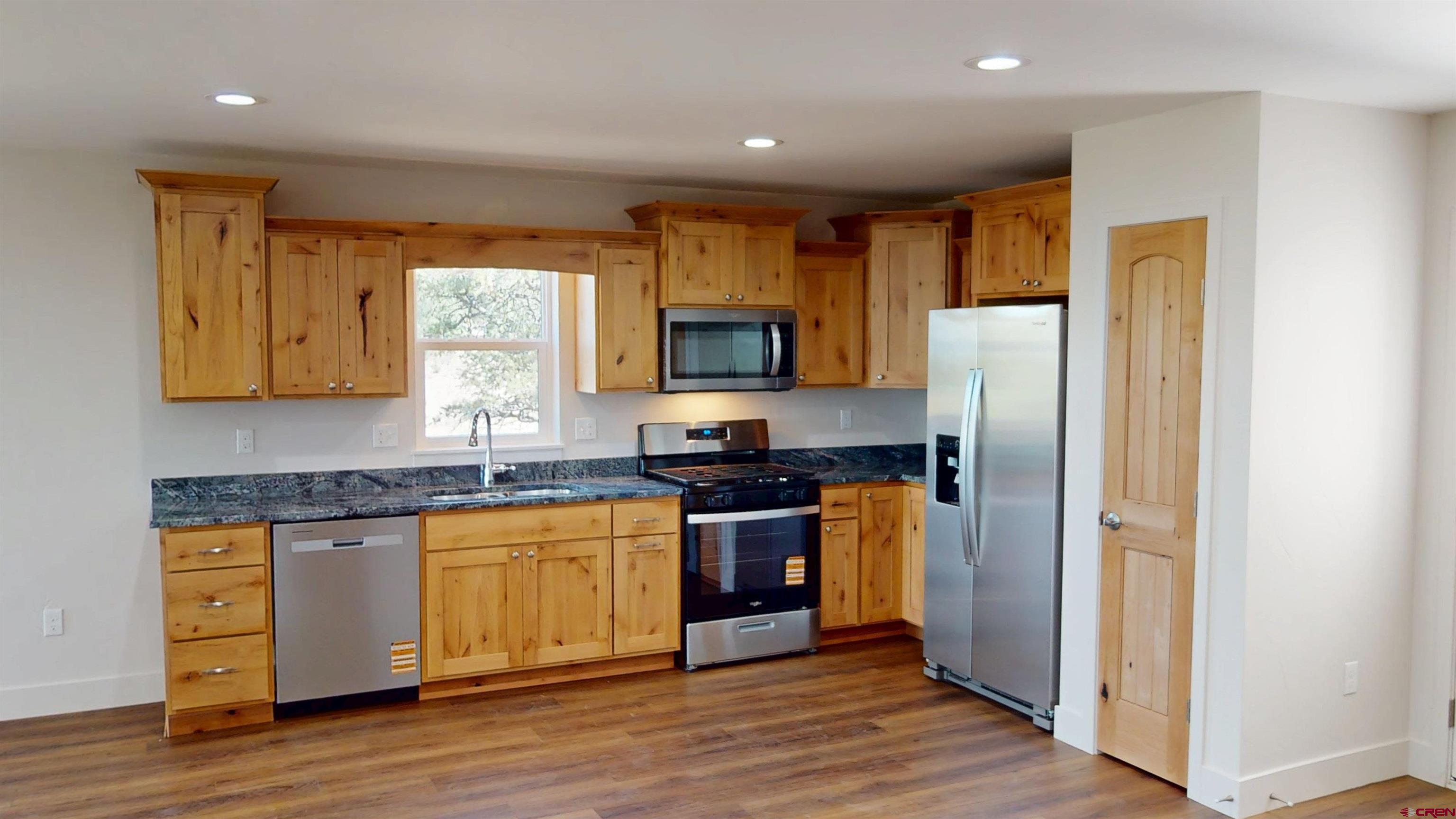 216 Baca Grant Way Crestone, CO 81131 - Photo 2 of 17 a kitchen with stainless steel appliances granite countertop a refrigerator and a stove top oven