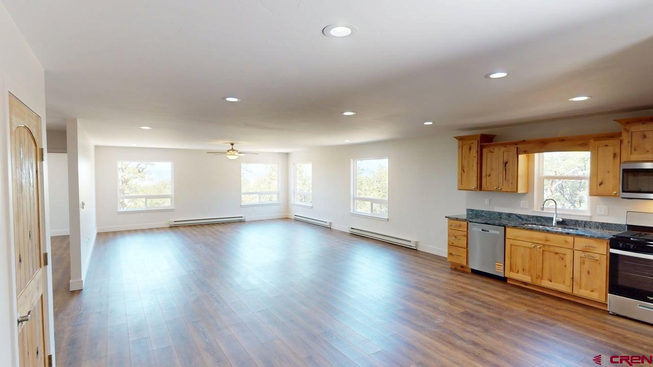 216 Baca Grant Way Crestone, CO 81131 - Photo 3 of 17 an empty room with wooden floor and windows