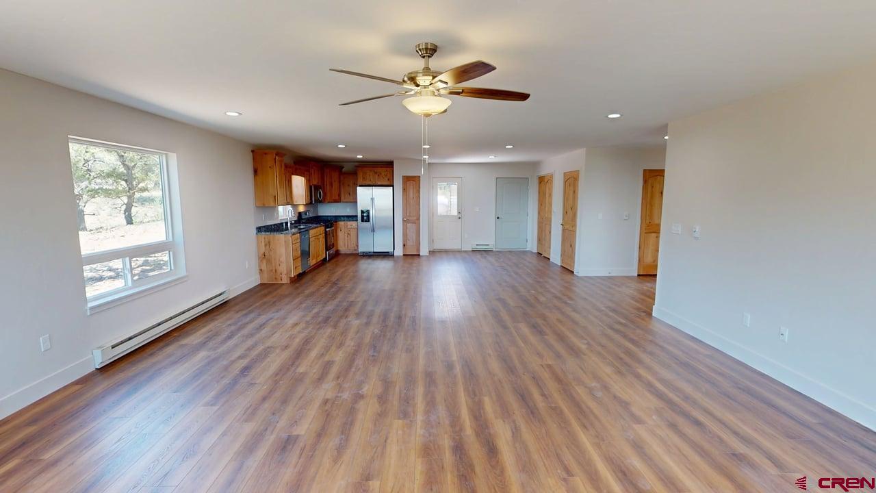 216 Baca Grant Way Crestone, CO 81131 - Photo 5 of 17 a view of empty room with wooden floor and fan