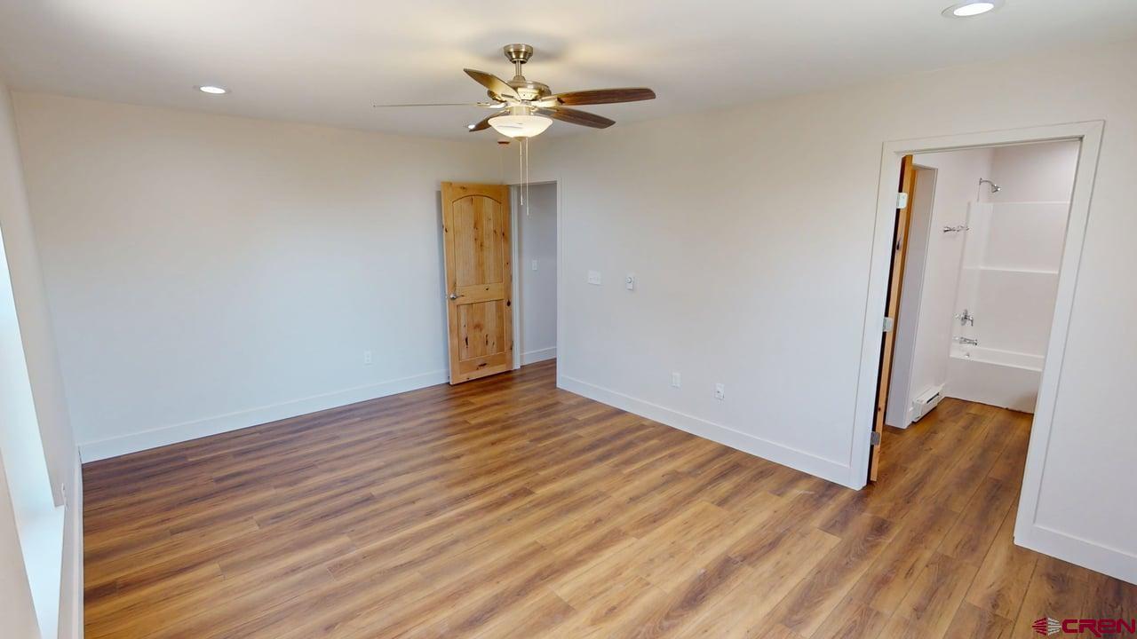 216 Baca Grant Way Crestone, CO 81131 - Photo 7 of 17 a view of an empty room with wooden floor and a ceiling fan