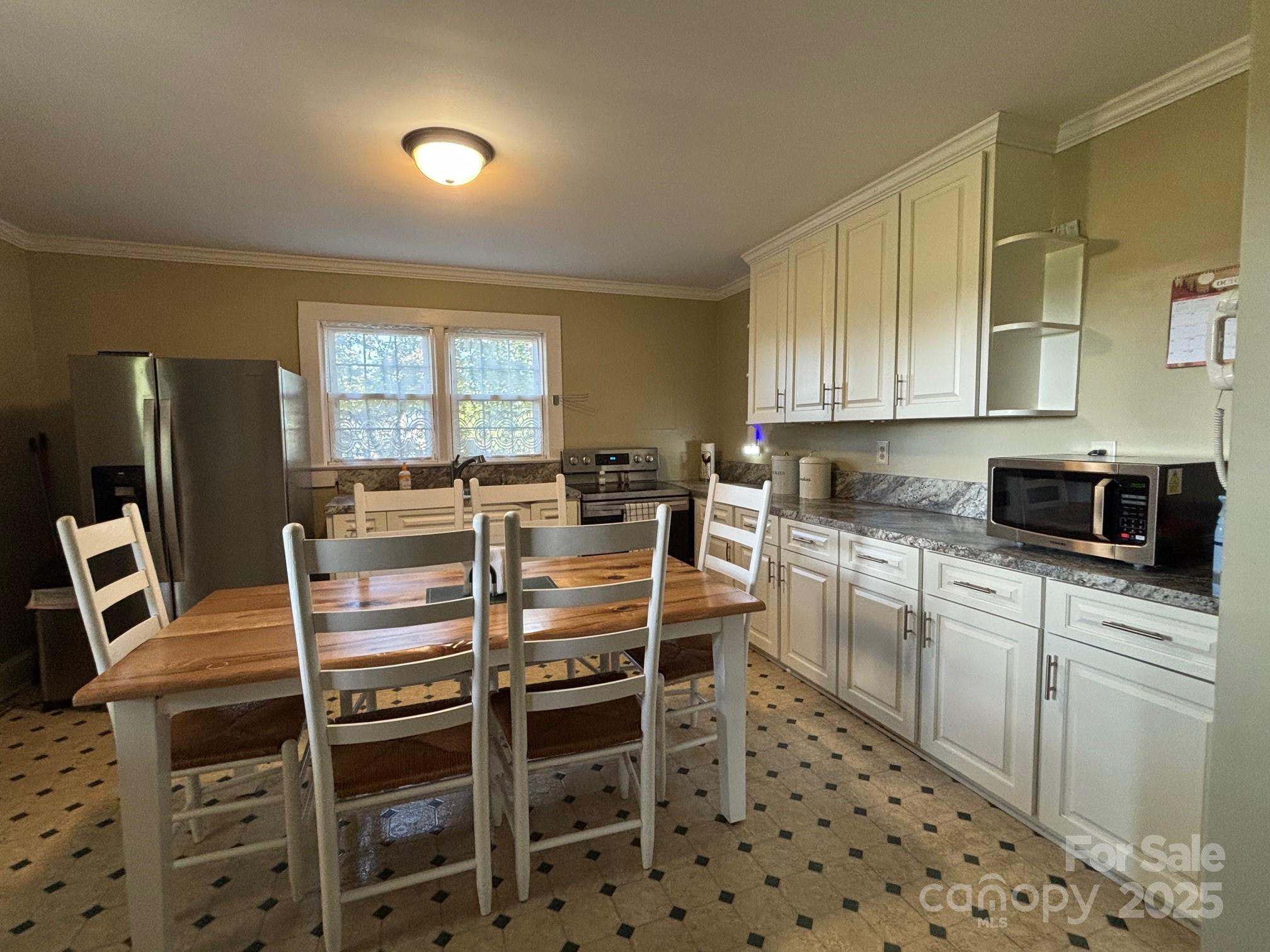 407 State Park Road Troutman, NC 28166 - Photo 8 of 21 a kitchen with stainless steel appliances kitchen island granite countertop a stove a sink a dining table and chairs