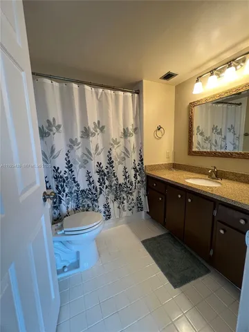 a spacious bathroom with a granite countertop sink a mirror and a bathtub