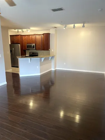 a view of a living room a kitchen and a wooden floor