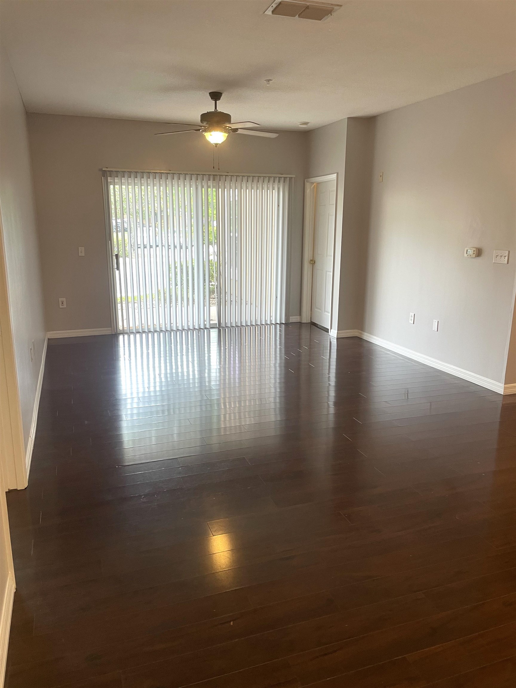 605 Fairway Drive, Unit 107 St. Augustine, FL 32084 - Photo 8 of 20 an empty room with wooden floor and windows