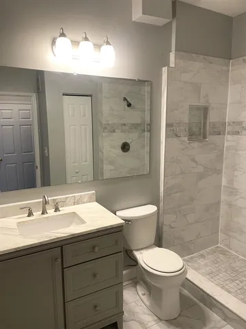 a bathroom with a sink a toilet and shower