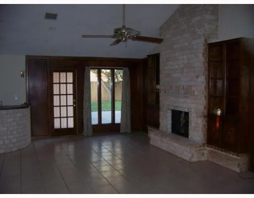 a view of an empty room with a fireplace and a window
