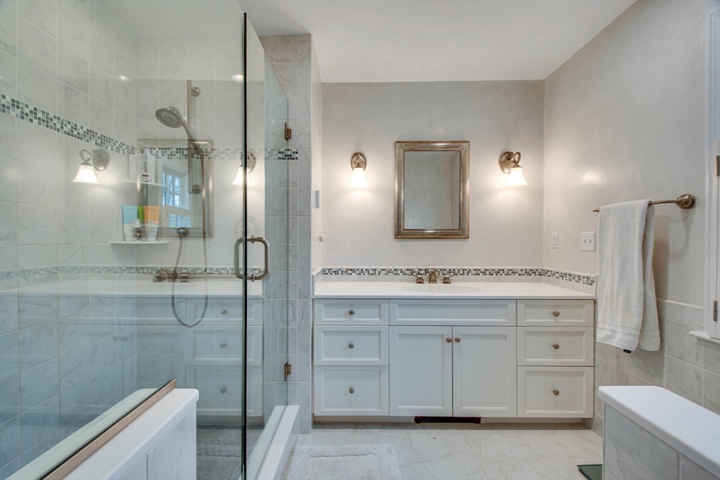 48 Miller Hill Road Dover, MA 02030 - Photo 14 of 26 a bathroom with a granite countertop sink a toilet a large mirror a shower and vanity