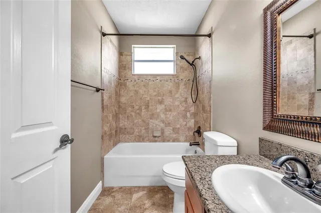 a bathroom with a granite countertop tub sink a mirror a shower and a bathtub