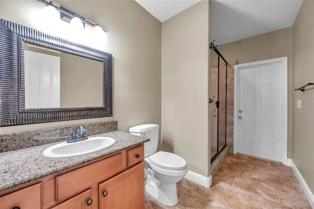a bathroom with a granite countertop sink toilet and shower