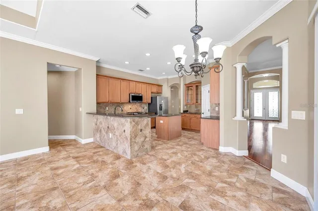 a view of a kitchen with granite countertop a refrigerator and a sink