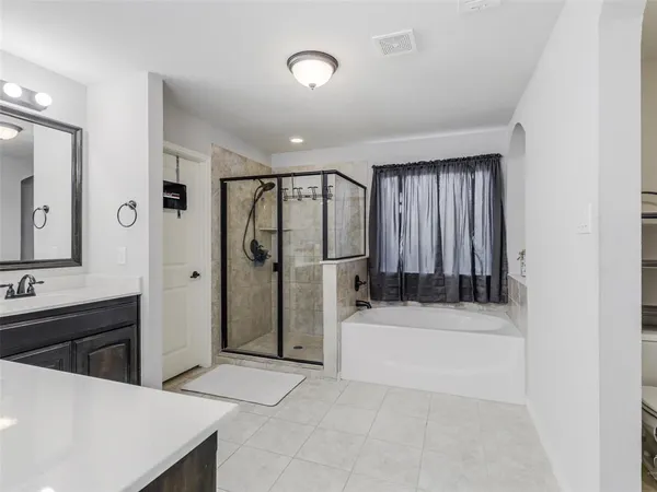 a spacious bathroom with a tub sink and mirror