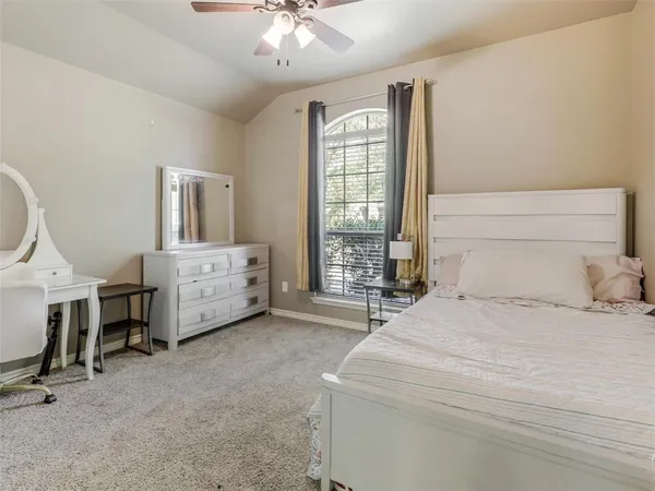 a bedroom with a bed a chandelier and a large window