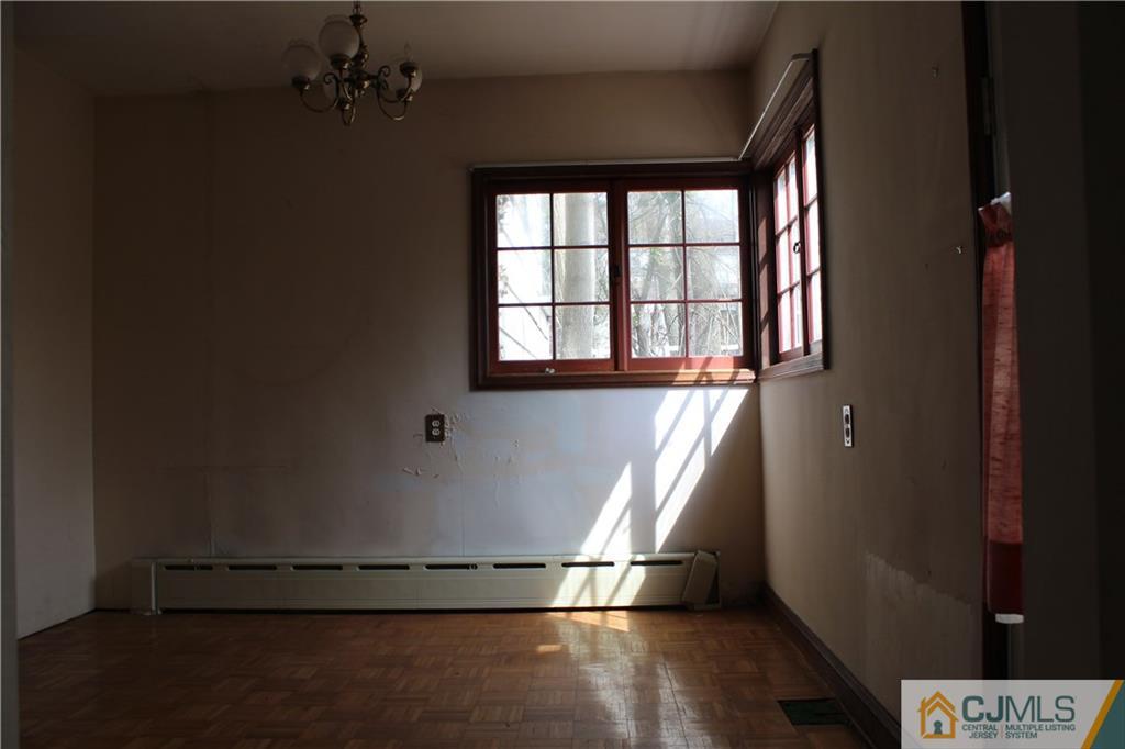 1 Edgebrook Road New Brunswick, NJ 08901 - Photo 6 of 8 an empty room with wooden floor and windows