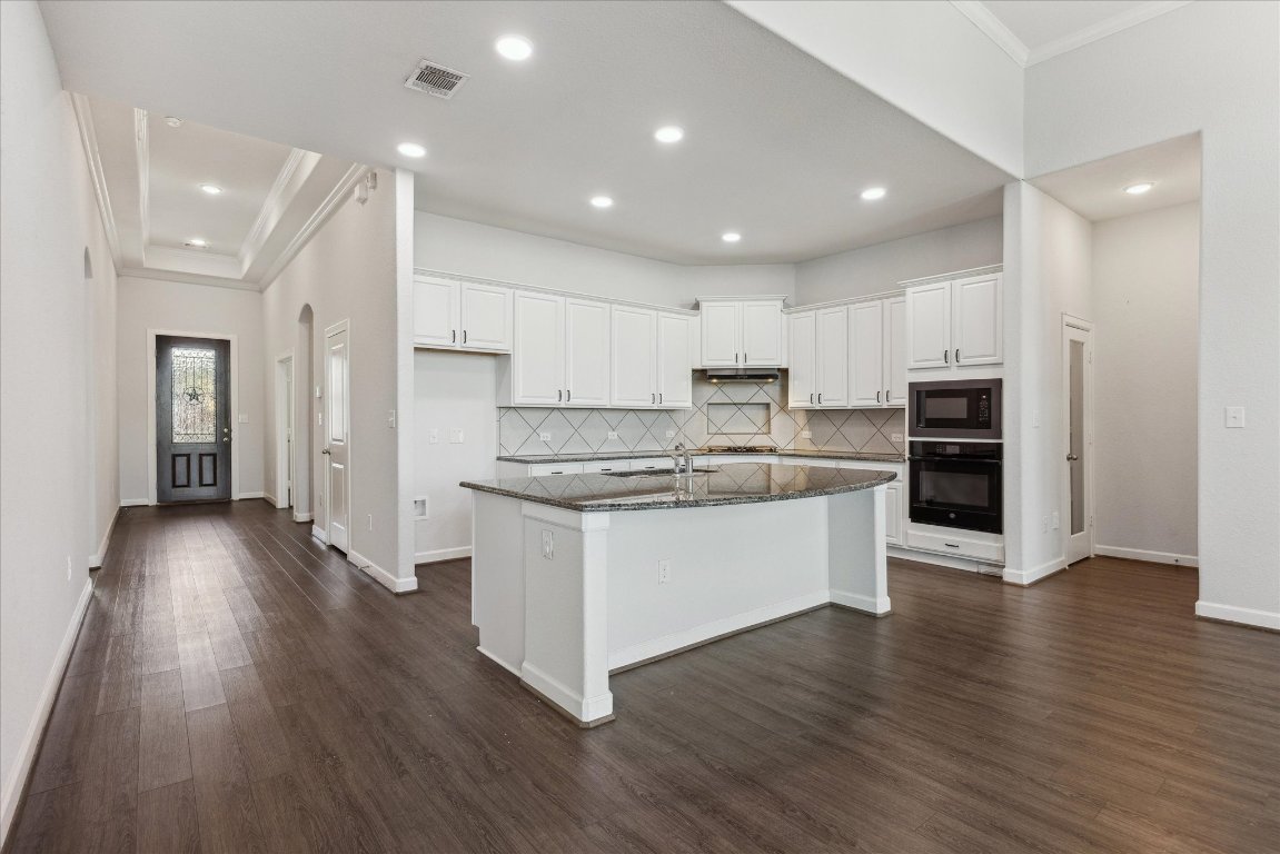 623 Baretta Loop Buda, TX 78610 - Photo 4 of 10 a large kitchen with stainless steel appliances granite countertop a large stove a refrigerator a sink and a oven with wooden floor