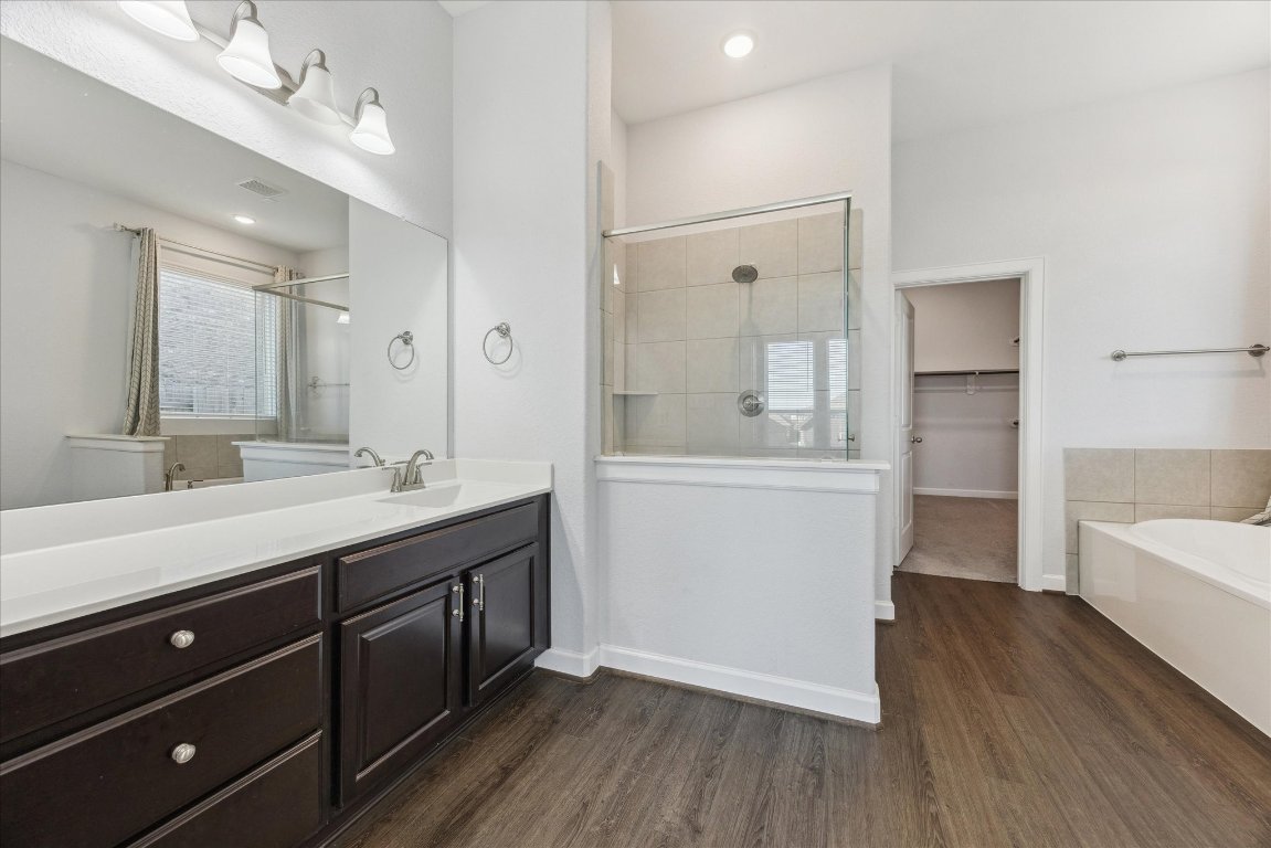 623 Baretta Loop Buda, TX 78610 - Photo 6 of 10 a bathroom with a sink a mirror a vanity and a bathtub