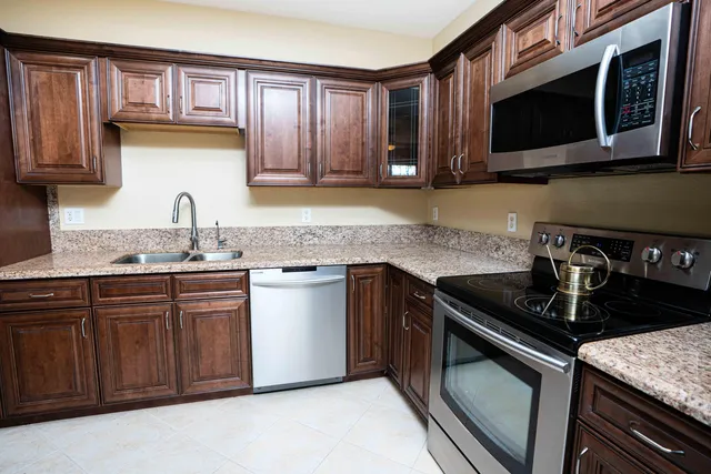 a kitchen with stainless steel appliances granite countertop a sink stove and microwave