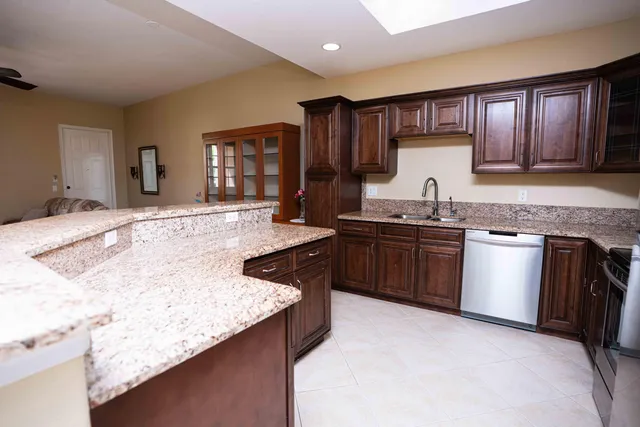 a kitchen with granite countertop sink stove and cabinets