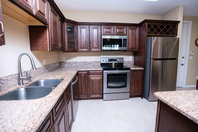 a kitchen with granite countertop a sink stove and refrigerator