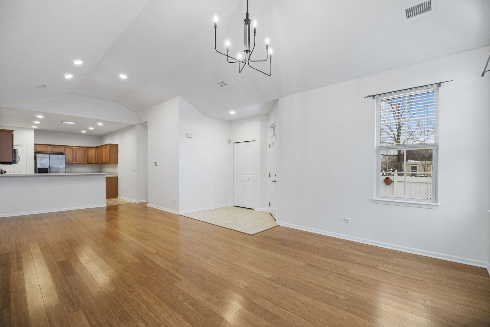 23908 Dayfield Drive, Unit 23908 Plainfield, IL 60586 - Photo 7 of 23 a view of an empty room with wooden floor and a window