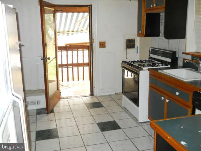 815 Pasadena Road Pasadena, MD 21122 - Photo 2 of 3 a kitchen with stainless steel appliances granite countertop a stove a sink and a microwave