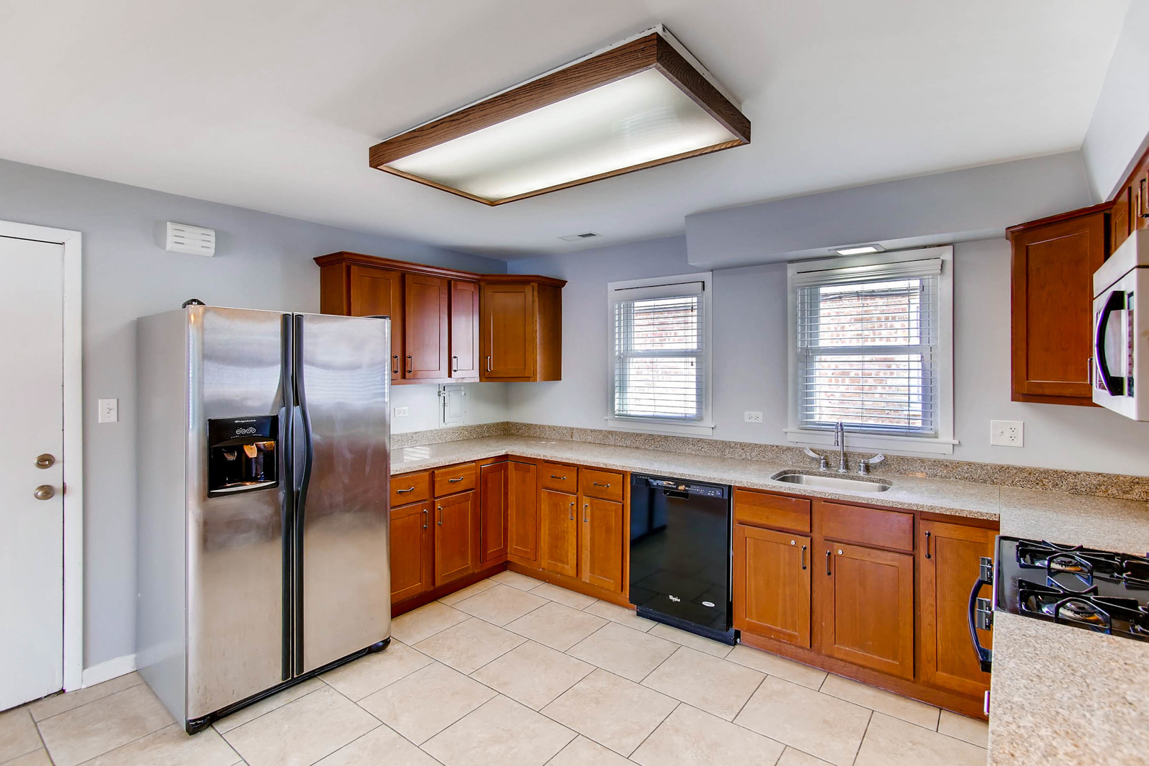 7233 38th Place Lyons, IL 60534 - Photo 13 of 26 a kitchen with stainless steel appliances granite countertop a refrigerator and a sink