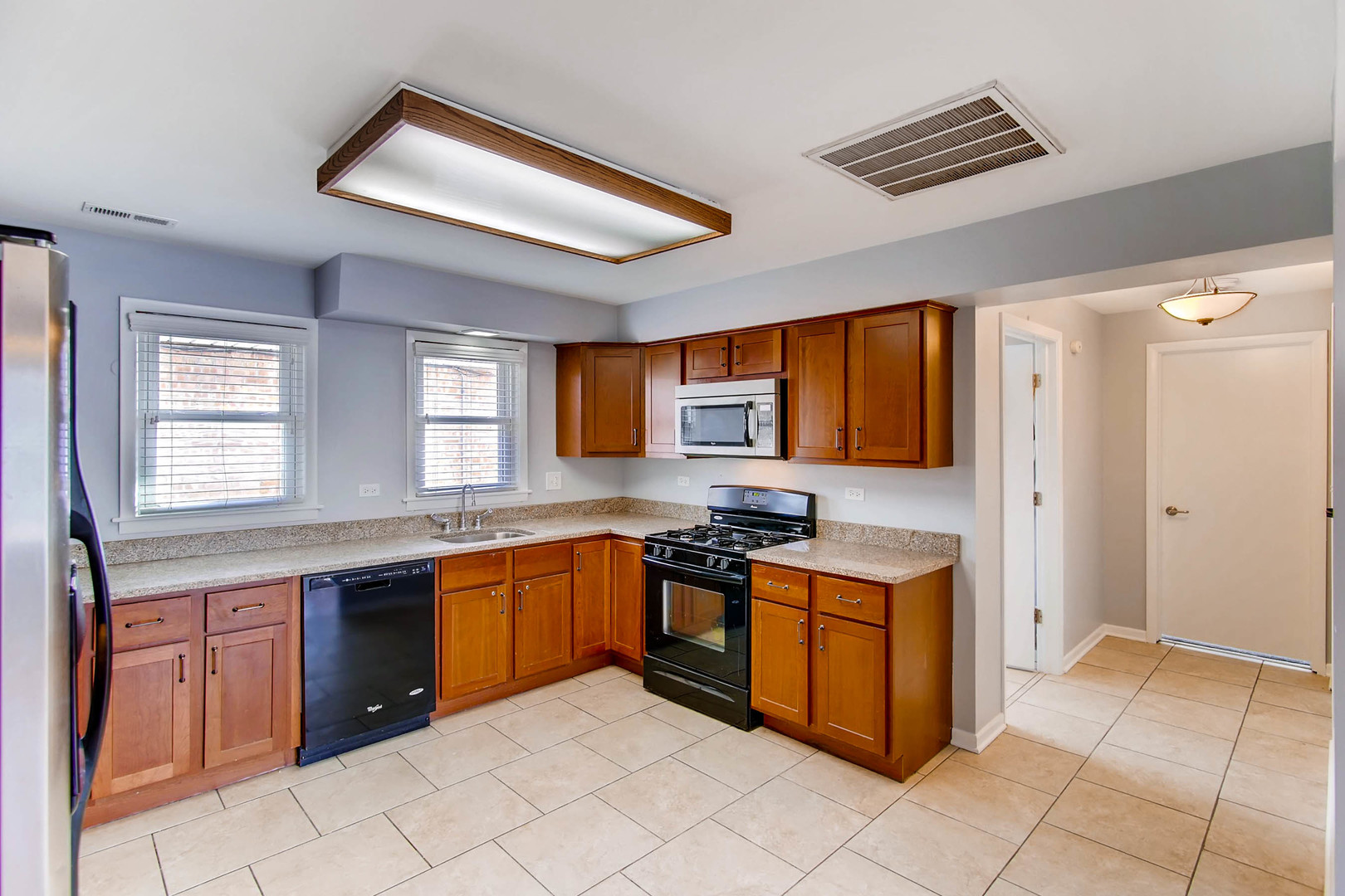 7233 38th Place Lyons, IL 60534 - Photo 14 of 26 a kitchen with stainless steel appliances granite countertop a stove sink and cabinets