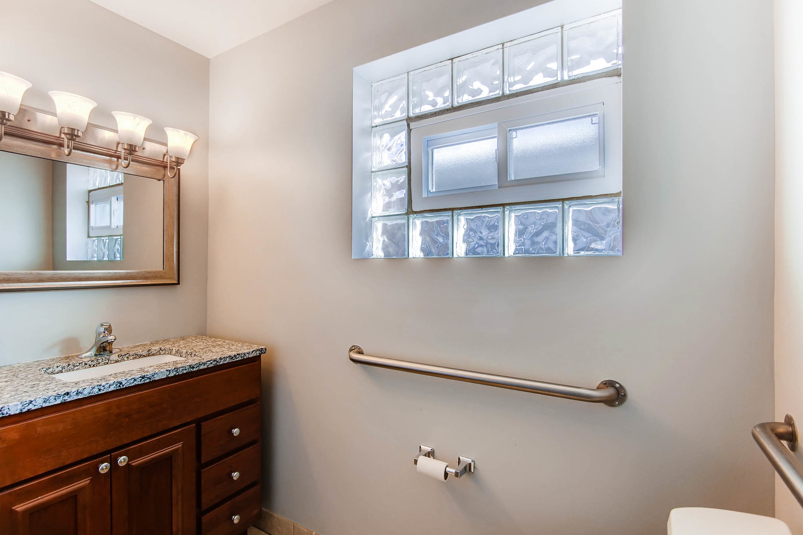 7233 38th Place Lyons, IL 60534 - Photo 22 of 26 a bathroom with a granite countertop sink a mirror and a shower