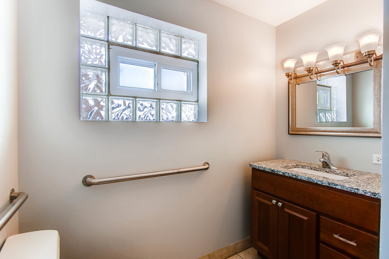 7233 38th Place Lyons, IL 60534 - Photo 23 of 26 a bathroom with a granite countertop sink a toilet and mirror