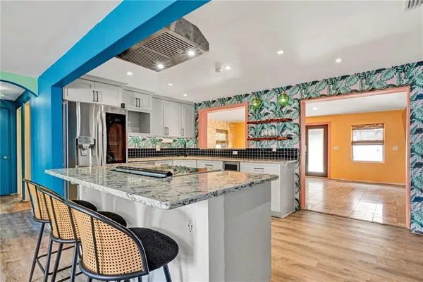 a kitchen with stainless steel appliances kitchen island granite countertop a stove and a refrigerator