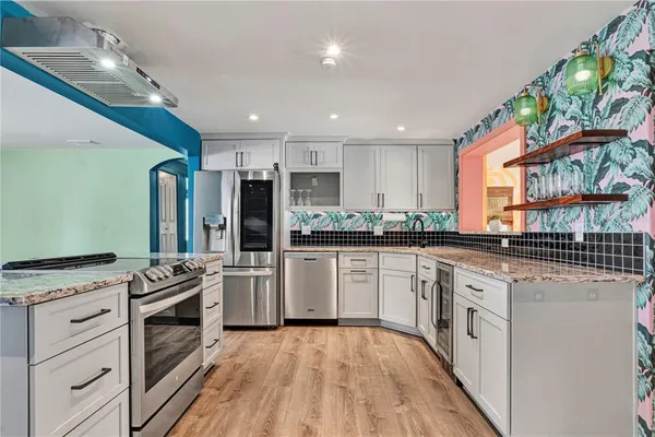 a kitchen with stainless steel appliances kitchen island granite countertop a stove and a refrigerator
