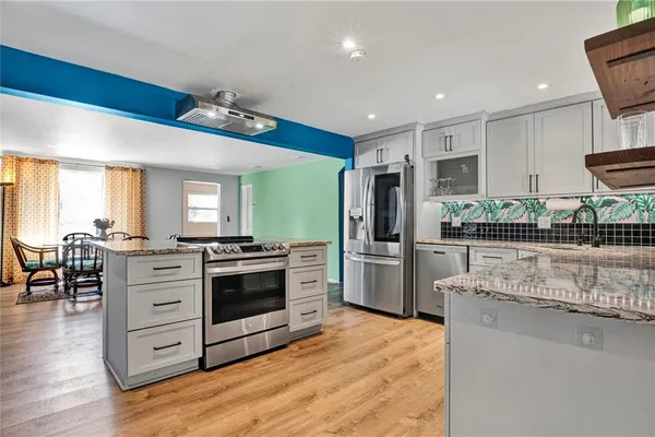 a kitchen with stainless steel appliances granite countertop a stove and cabinets