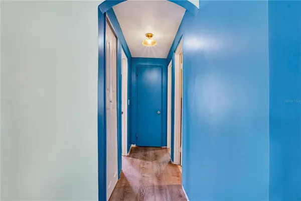 a view of an empty room with window and a kitchen