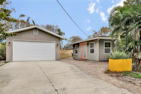 a view of a house with a yard and potted plants