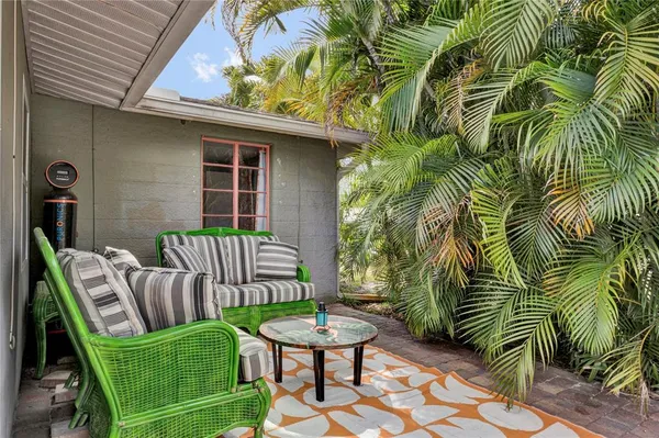 a view of a chair and table in backyard of the house