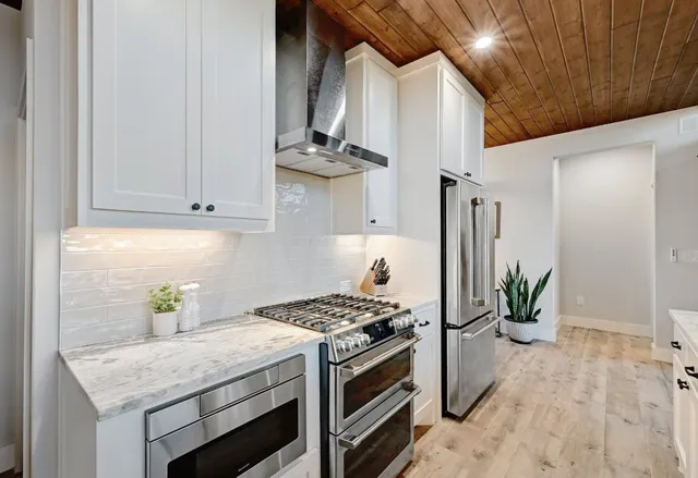 a kitchen with stainless steel appliances granite countertop a sink a stove and a refrigerator