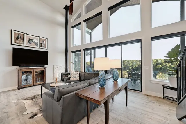 a living room with furniture a flat screen tv and a floor to ceiling window
