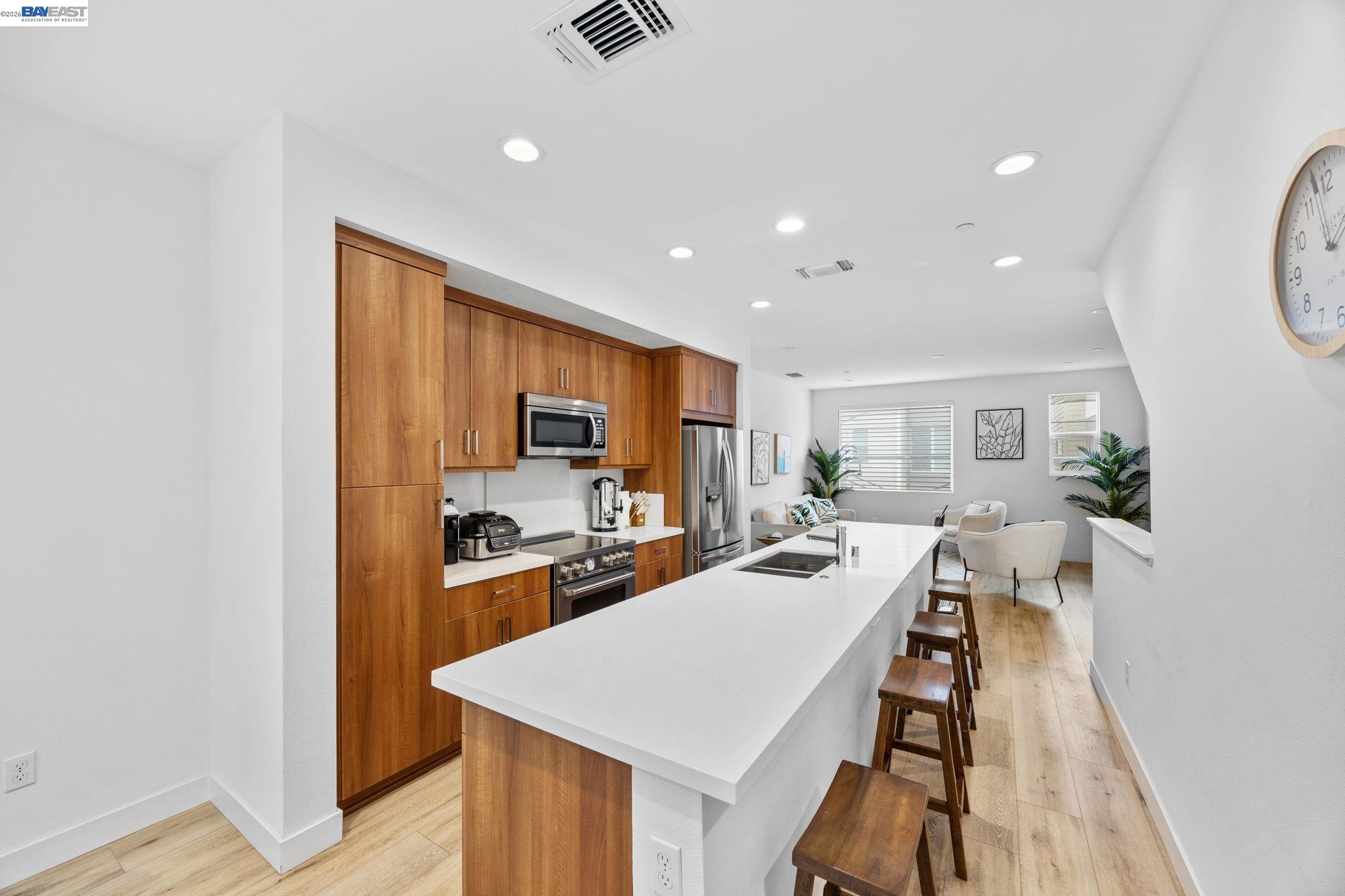 a large kitchen with sink a counter top space and stainless steel appliances