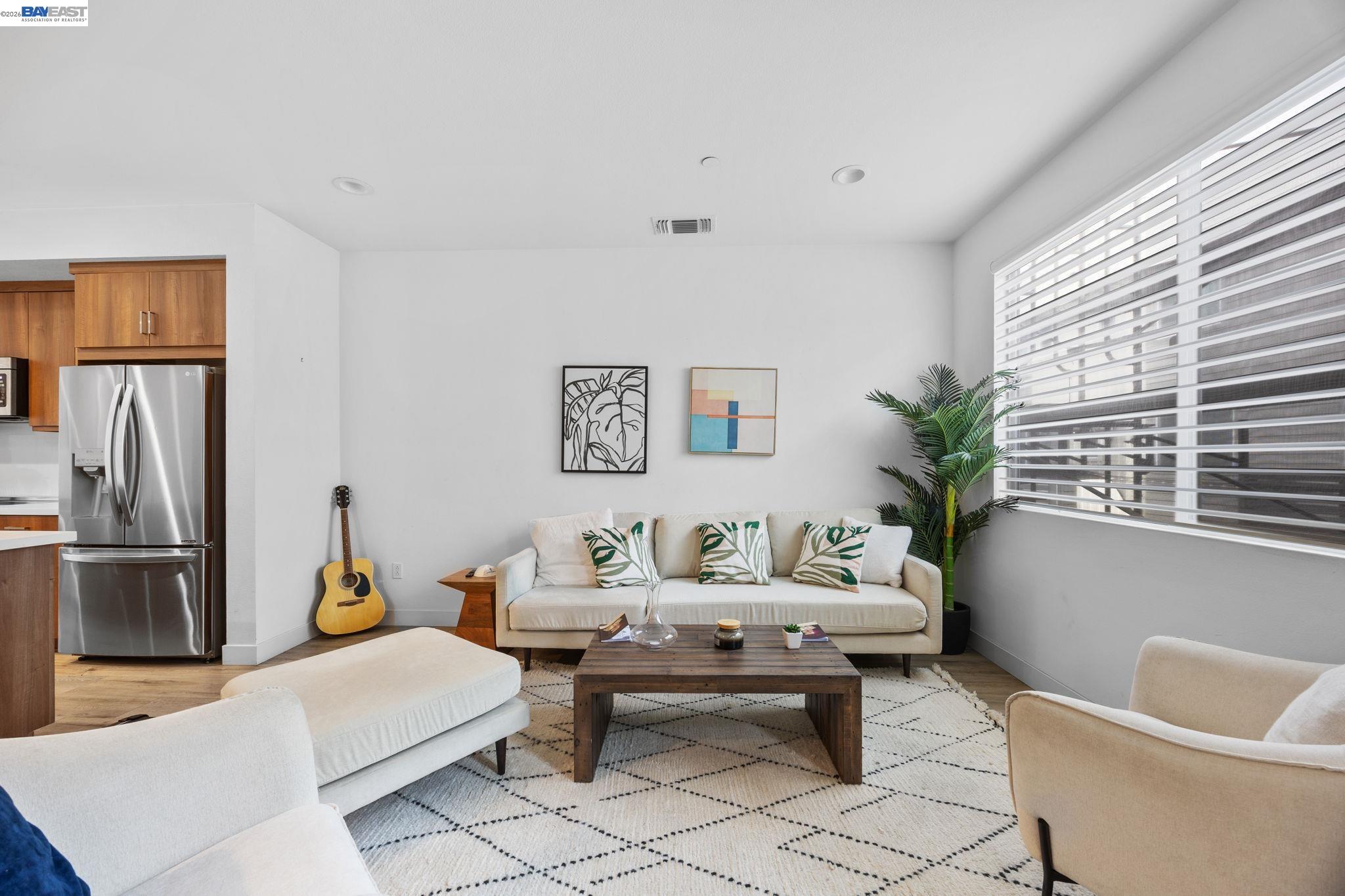 117 Uptown Circle Oakland, CA 94607 - Photo 2 of 7 a living room with furniture a window and a refrigerator