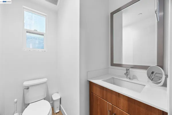 a bathroom with a granite countertop sink mirror and toilet